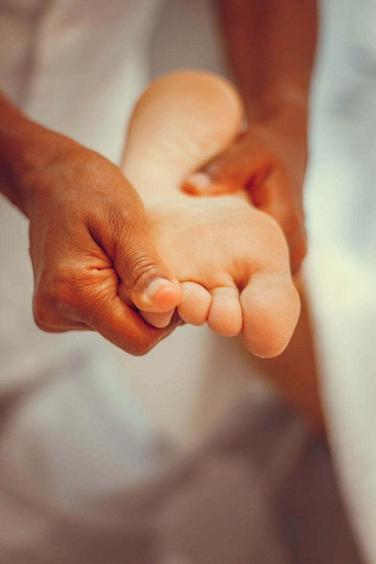 Close-up of a person giving a foot massage, gently pressing the sole of the foot, podiatry.